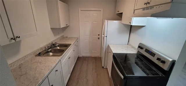 a kitchen with a stove a sink and a refrigerator