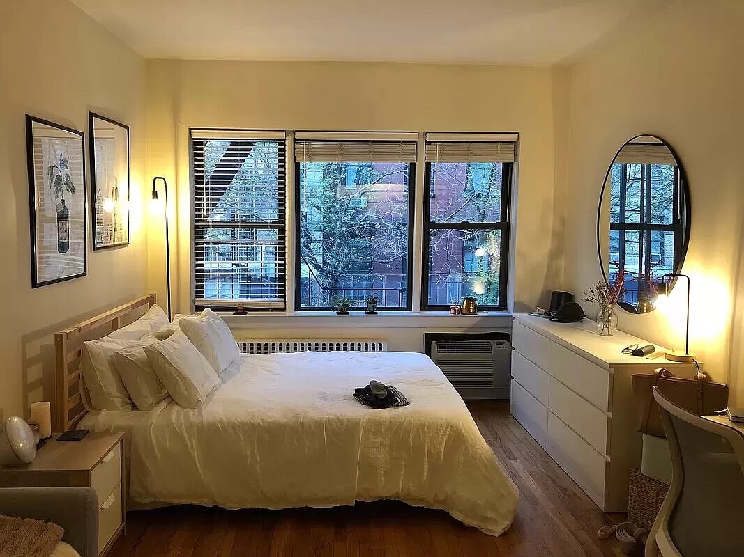 a spacious bedroom with a bed and a large window