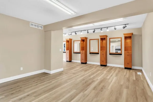 a view of an empty room with wooden floor and stairs