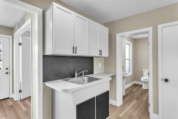 a kitchen with a sink cabinets and a wooden floor