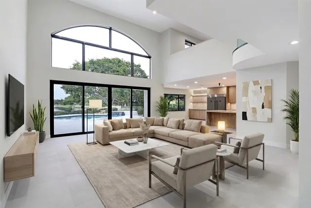a living room with furniture large windows and a flat screen tv