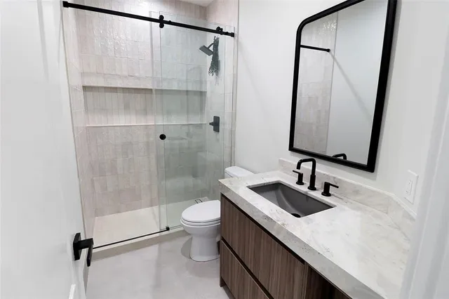 a bathroom with a sink a toilet and shower