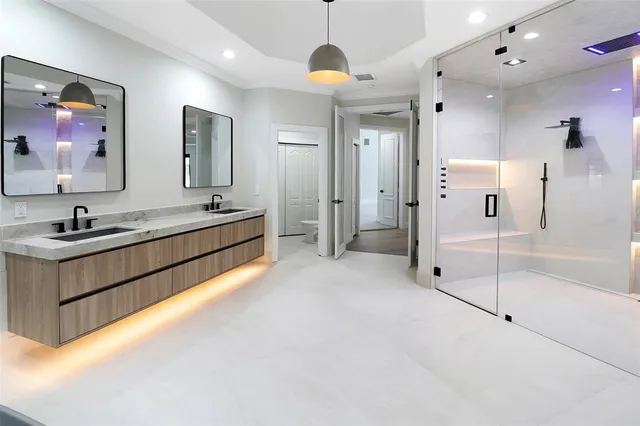 a spacious bathroom with a double vanity sink mirror and shower