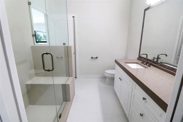a bathroom with a double vanity sink a toilet and a mirror