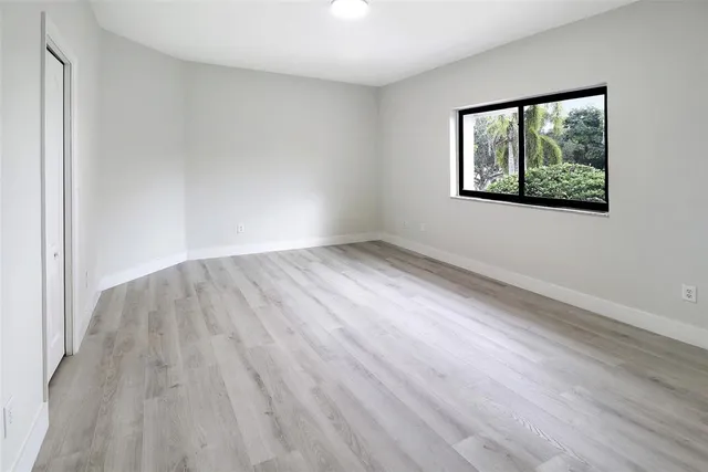 wooden floor in an empty room with a window