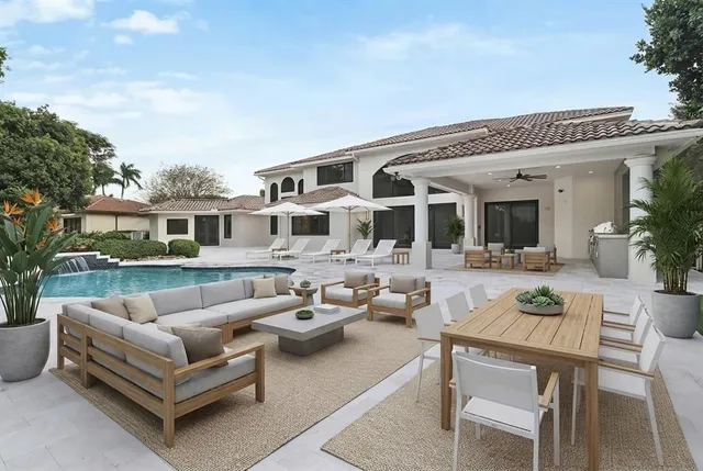 a view of a patio with couches table and chairs and potted plants