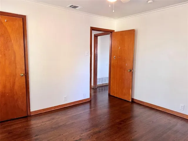an empty room with wooden floor and closet