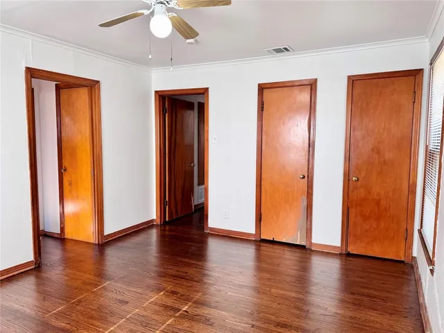 an empty room with wooden floor and closet area