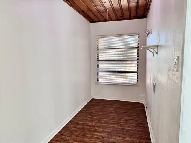 a view of a small space with wooden floor and a window