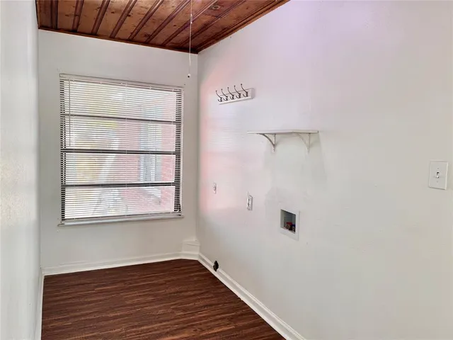 a view of a hallway with wooden floor and a window