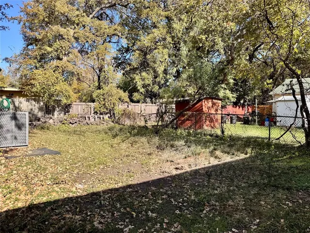 a view of a yard with wooden fence