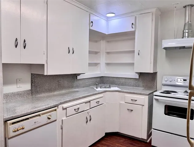 a kitchen with granite countertop white cabinets and white appliances