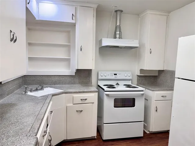 a kitchen with granite countertop white cabinets and white appliances