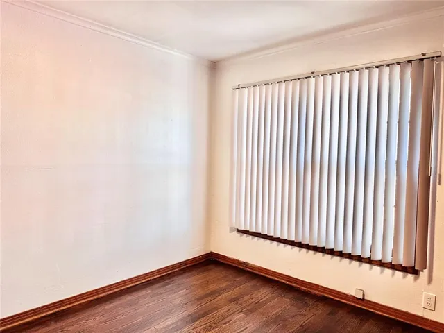 a view of a room with wooden floor and a window