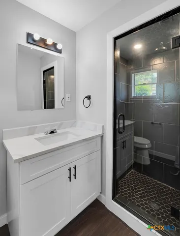a bathroom with a sink toilet a mirror and shower