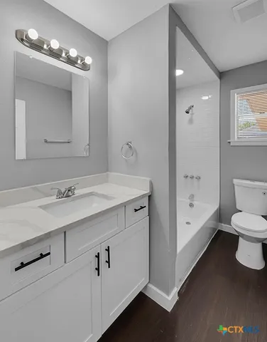 a bathroom with a sink a large mirror and a bathtub