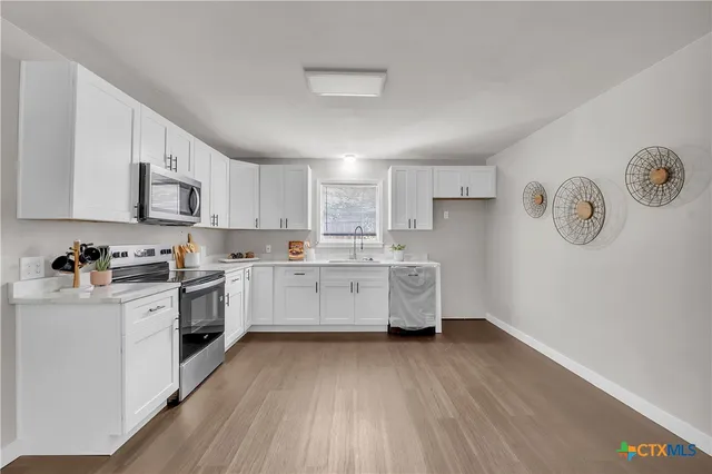 a kitchen with cabinets a sink and wooden floors