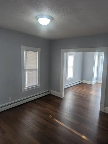 a view of empty room with wooden floor