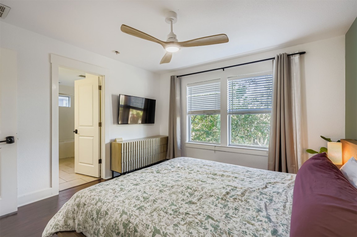 1601 Miriam Avenue, Unit 302 Austin, TX 78702 - Photo 16 of 29 Bedroom featuring dark wood-type flooring, ceiling fan, and ensuite bath