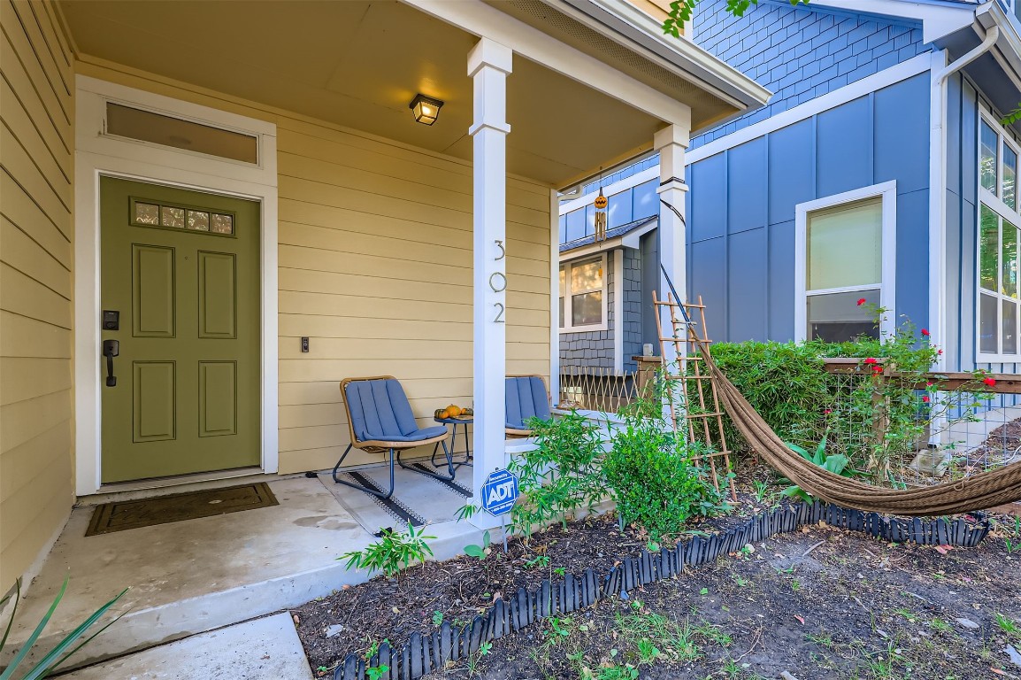 1601 Miriam Avenue, Unit 302 Austin, TX 78702 - Photo 2 of 29 Doorway to property featuring covered porch and board and batten siding