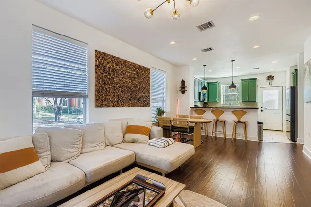 a living room with furniture wooden floor and a large window