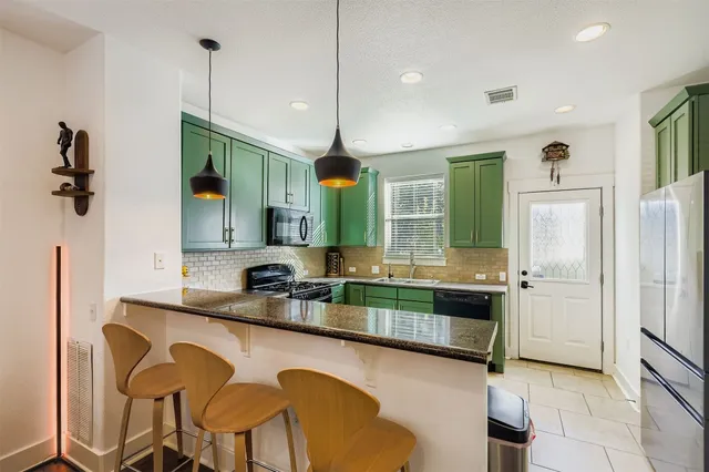 a kitchen with stainless steel appliances granite countertop a sink a stove and a refrigerator