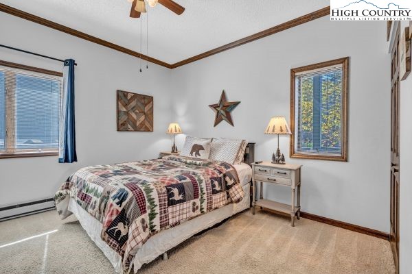 144 Skyleaf Lane, Unit 703 Sugar Mountain, NC 28604 - Photo 19 of 29 a bedroom with a bed lamp and paintings on the wall