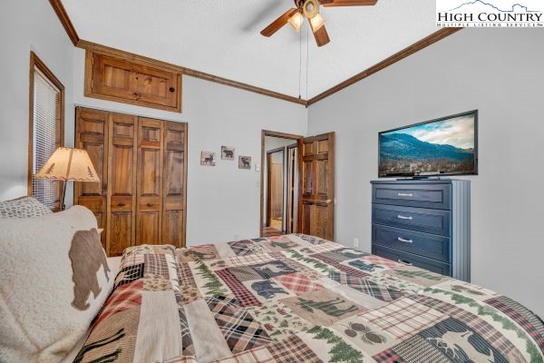 144 Skyleaf Lane, Unit 703 Sugar Mountain, NC 28604 - Photo 20 of 29 a bedroom with a bed and a flat tv screen on dresser