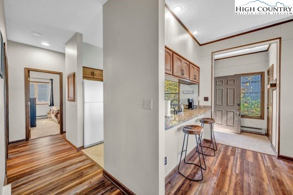144 Skyleaf Lane, Unit 703 Sugar Mountain, NC 28604 - Photo 5 of 29 a view of a hallway with wooden floor windows and a living room