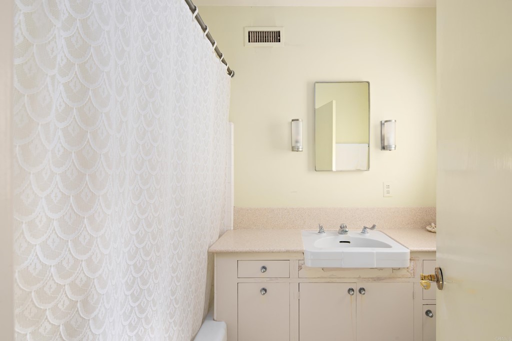 1380 Park Row La Jolla, CA 92037 - Photo 23 of 51 a bathroom with a sink and mirror