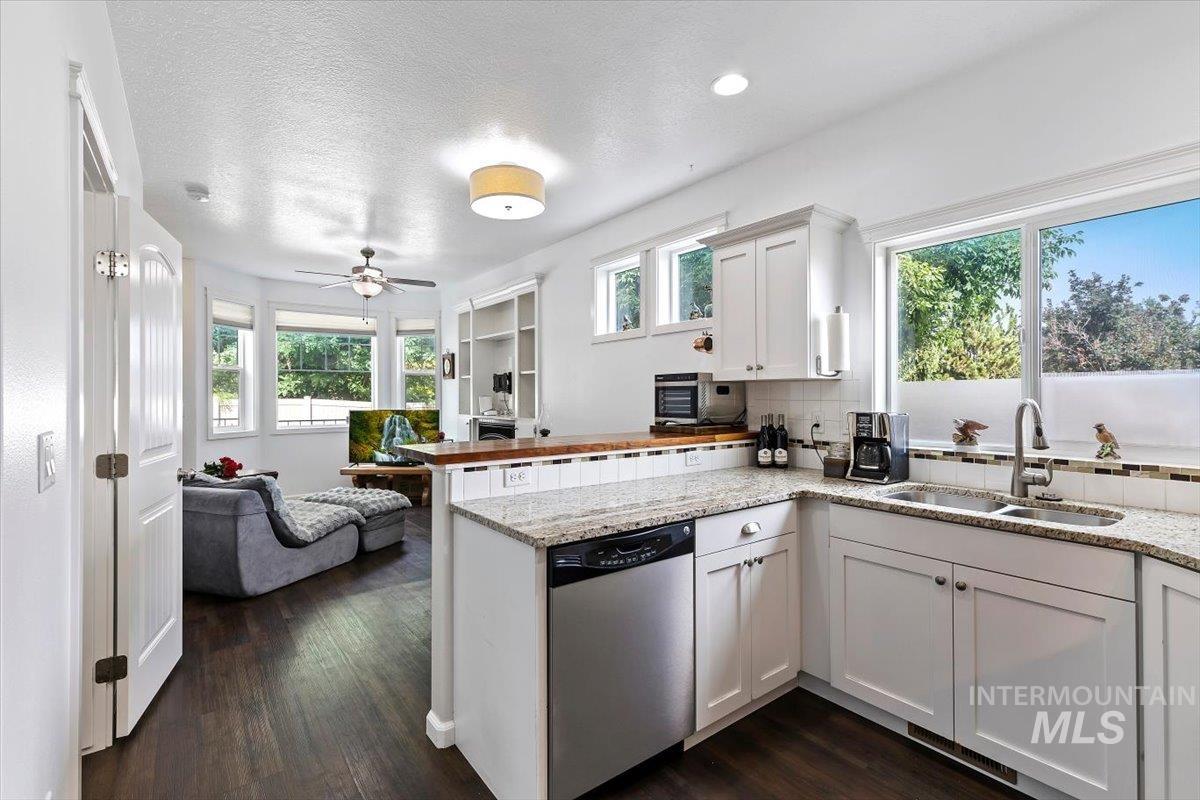 4390 North Five Mile Road Boise, ID 83704 - Photo 7 of 23 White shaker cabinetry with granite countertops, stainless steel appliances, wood-finish flooring, and recessed lighting