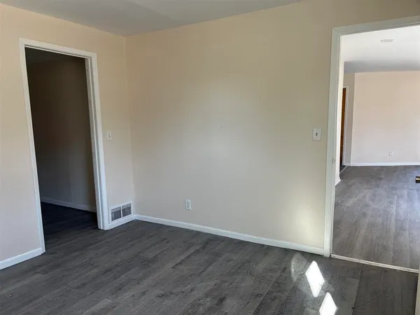 an empty room with wooden floor and closet