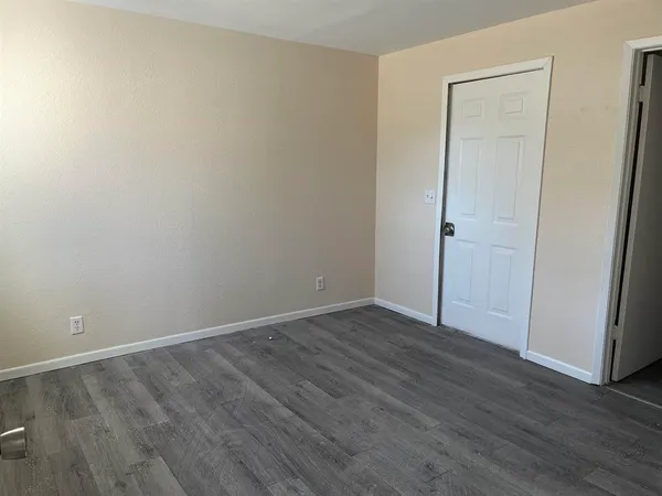 an empty room with wooden floor and closet