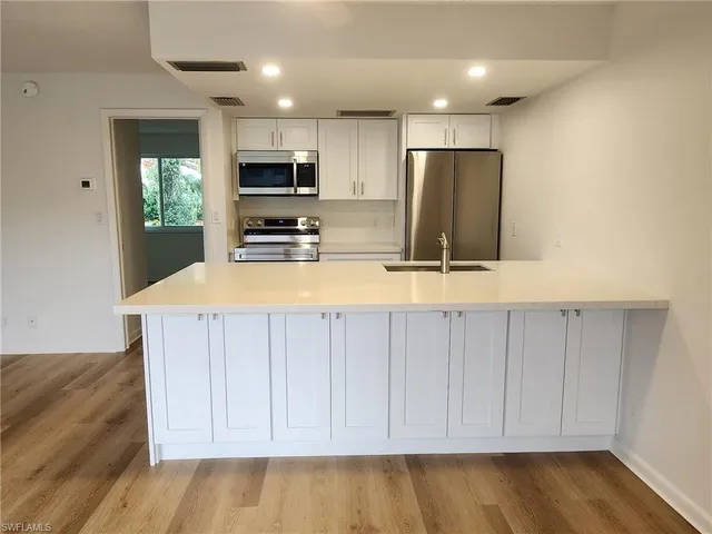 a kitchen with a refrigerator and a stove top oven