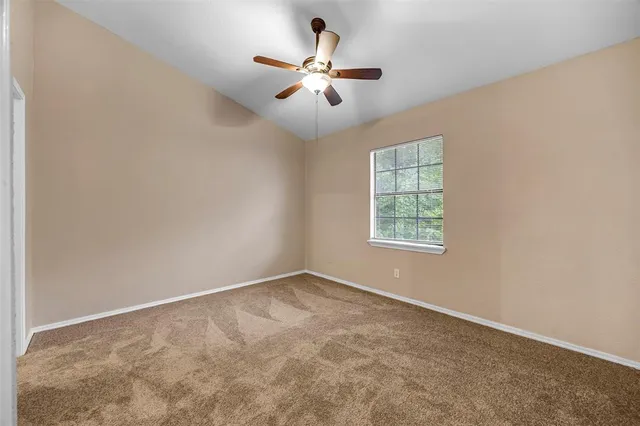 an empty room with fan and windows