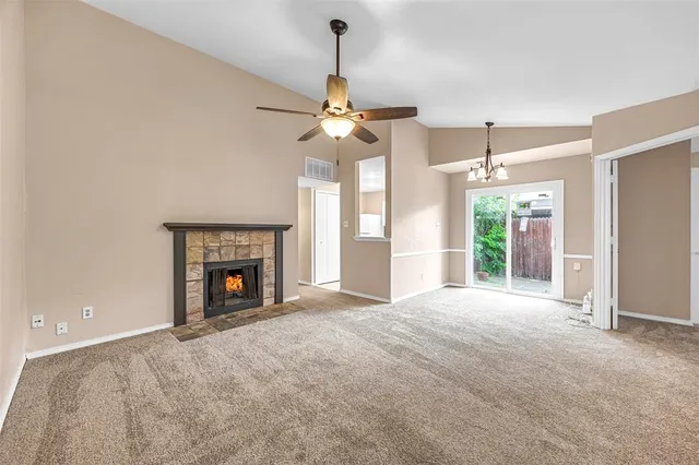 a view of an empty room with a fireplace and a window