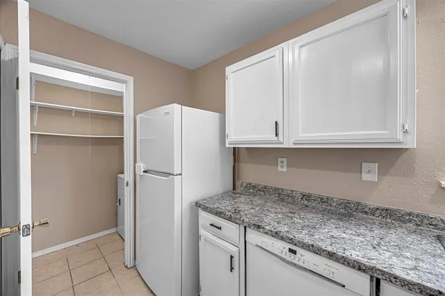 a kitchen with granite countertop cabinets and refrigerator