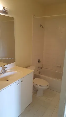 a bathroom with a granite countertop toilet and a sink