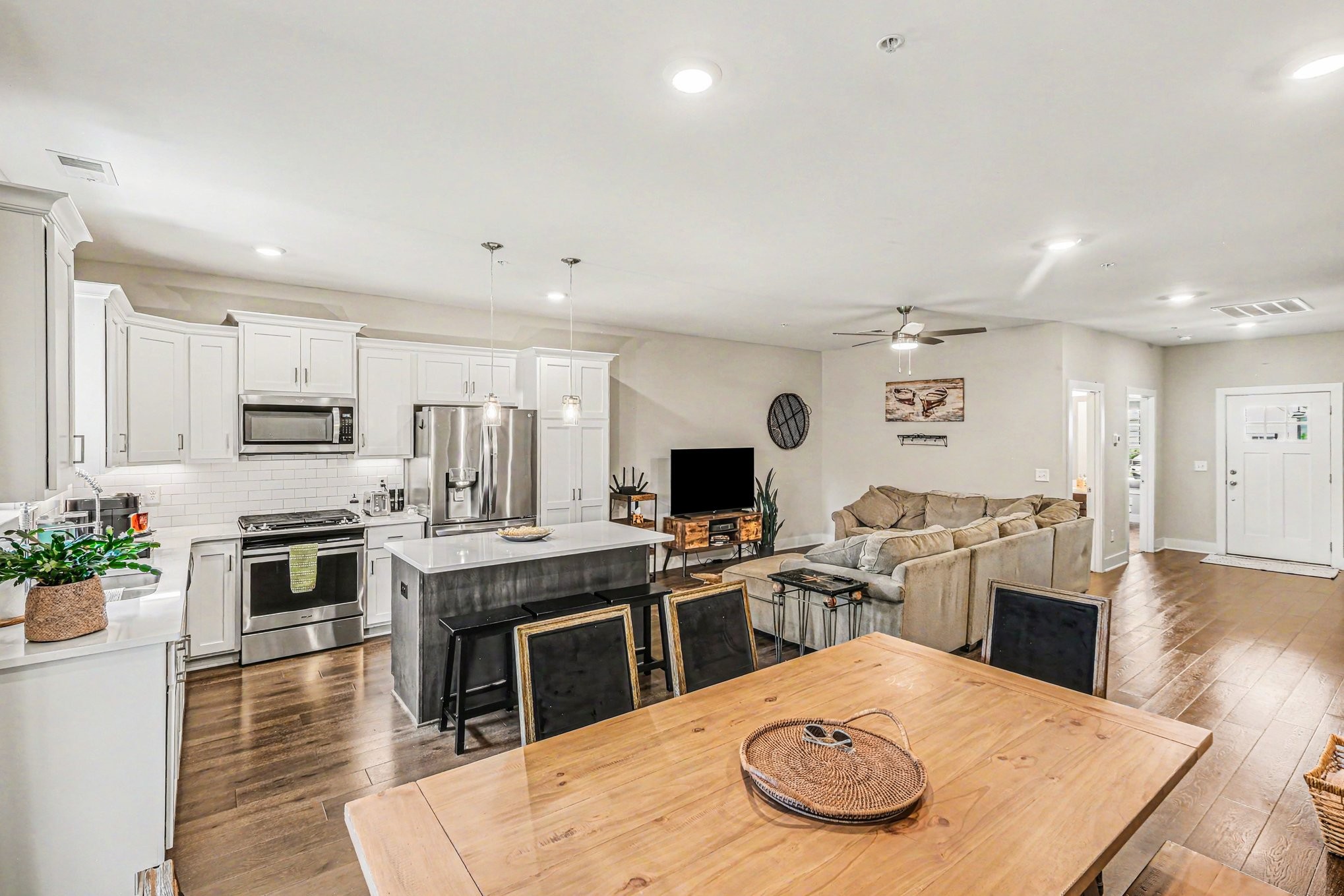 1144 Lock 4 Road, Unit H3 Gallatin, TN 37066 - Photo 9 of 22 a kitchen with stainless steel appliances kitchen island granite countertop a stove top oven a sink a dining table and chairs with wooden floor