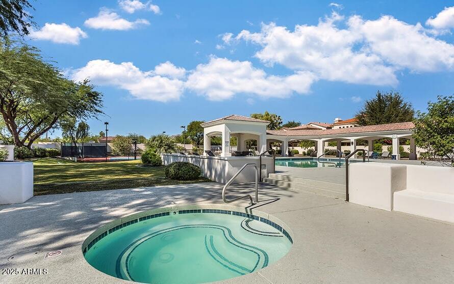 7614 East Cactus Wren Road Scottsdale, AZ 85250 - Photo 17 of 22 a view of a swimming pool with lawn chairs under an umbrella