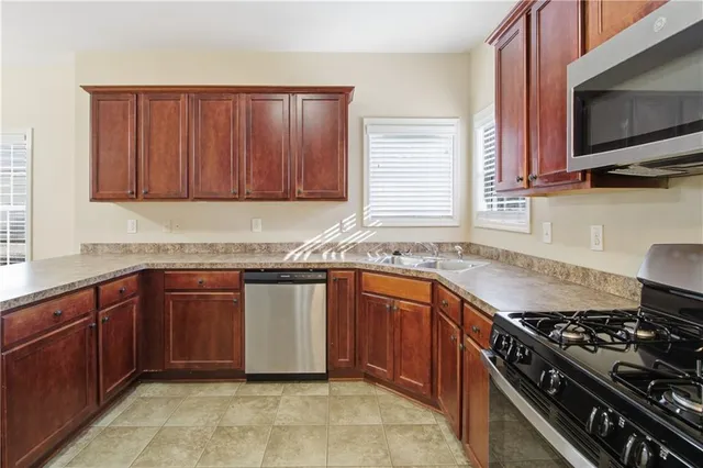 a kitchen with granite countertop wooden cabinets and stainless steel appliances