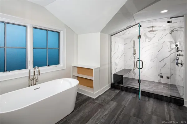 a bathroom with a tub a sink and a shower