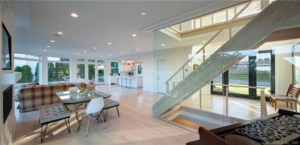 a living room with furniture and a dining table with wooden floor