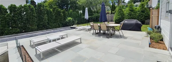 a view of a patio with a table and chairs and a barbeque