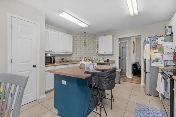 a kitchen with stainless steel appliances a sink a stove a refrigerator cabinets and a window