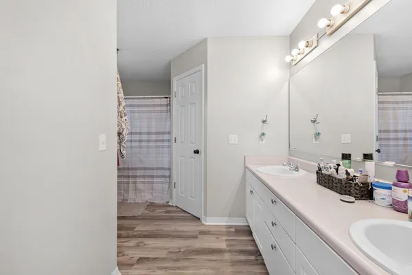 a bathroom with a double vanity sink a mirror and a shower