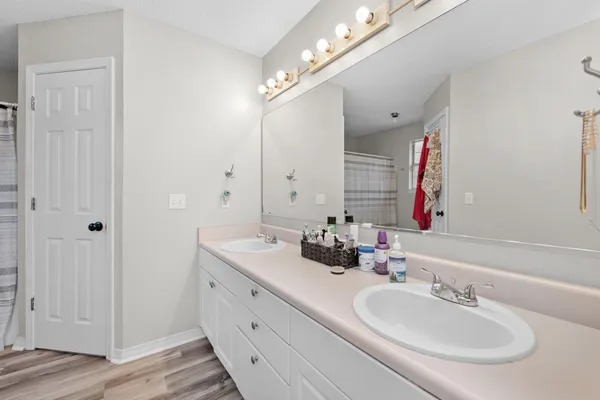 a bathroom with double vanity sinks and a mirror