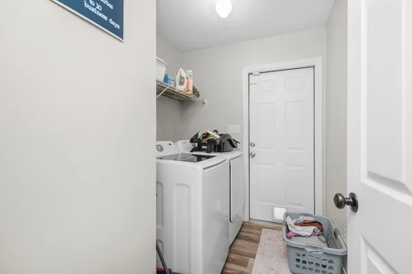 a walk in closet with wooden floor