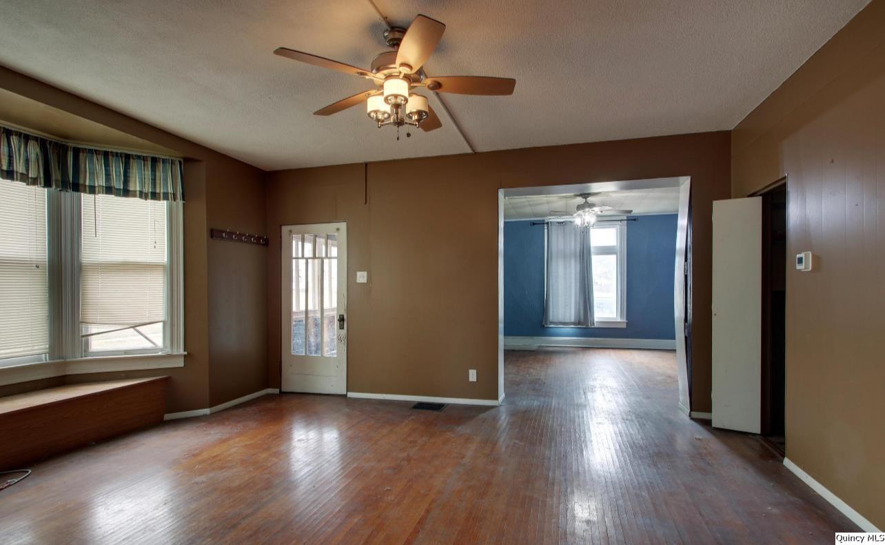 623 Payson Avenue Quincy, IL 62301 - Photo 3 of 13 an empty room with wooden floor and windows