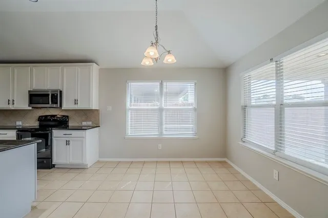 a kitchen with granite countertop a stove a sink and a microwave